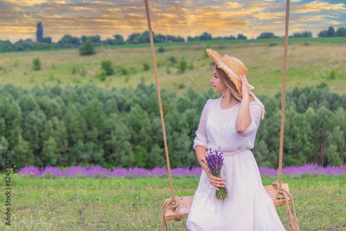 girl on a swing in a field of lavender. Selective focus