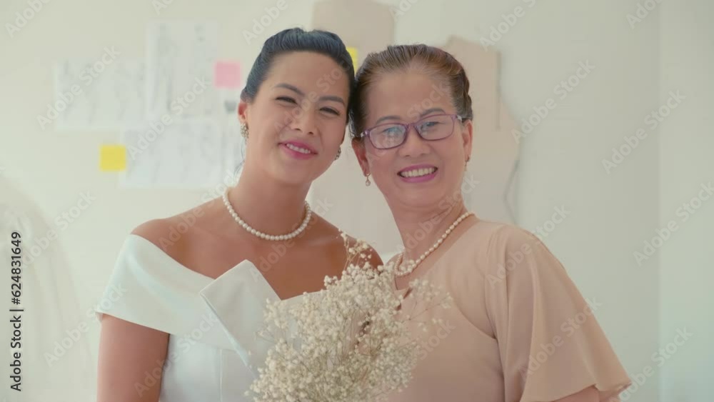 Portrait of happy bride with her mother on wedding day holding flowers and smiling at camera Portrait of happy bride with her mother on wedding day holding flowers and smiling at camera