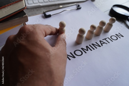 фотографія Hand pick wooden doll and text NOMINATION