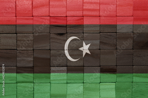 colorful painted big national flag of libya on a wooden cubes texture.