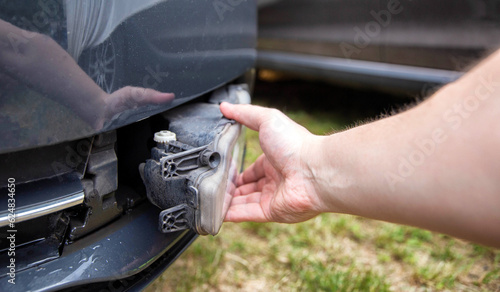 Disassembling and removing the fog lamp from a car to replace a burnt out light bulb. Close-up