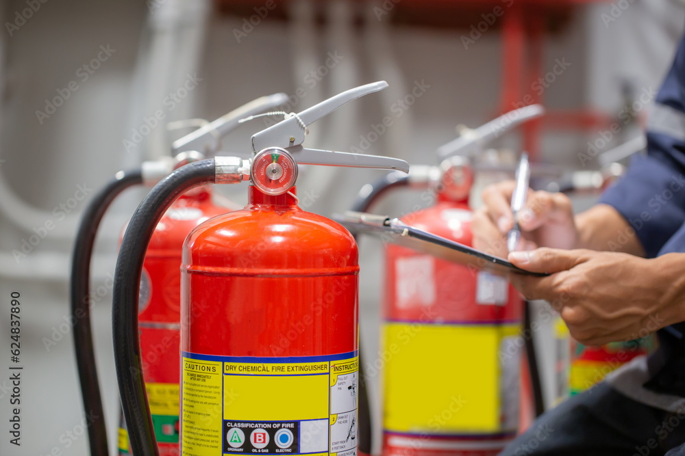 Engineer are checking and inspection a fire extinguishers tank in the fire control room for safety training and fire prevention. Engineer are checking and inspection a fire extinguishers tank in the fire control room for safety training and fire prevention.