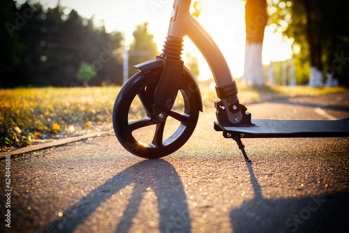 Scooter wheel on the background of a sunset in summer, close-up. Scooter rental business concept. Self-sharing. photo