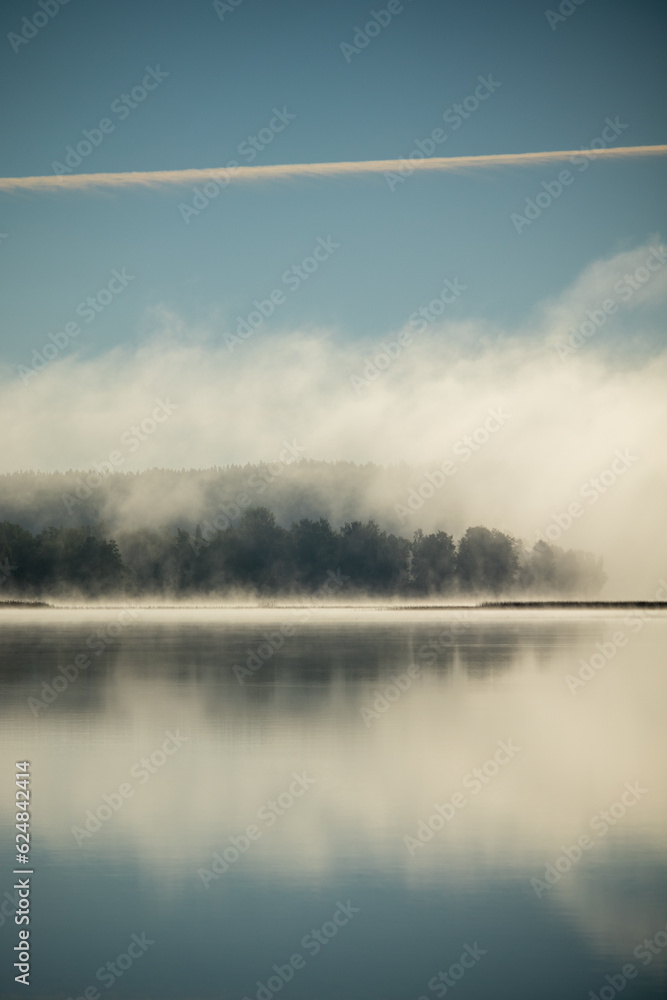 Misty morning on top of a still reflecting lake. Misty morning on top of a still reflecting lake.