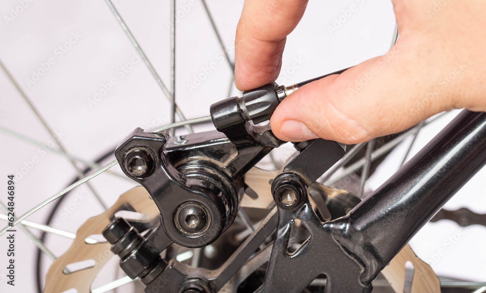 Adjusting the tension of the bicycle brake caliper cable. Brake setting. Copy space for text. Close-up Adjusting the tension of the bicycle brake caliper cable. Brake setting. Copy space for text. Close-up