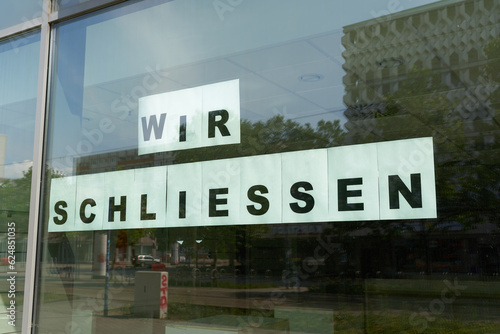 Schild mit der Aufschrift wir schließen am Schaufenster eines Geschäfts in Magdeburg photo