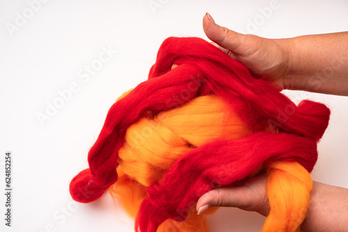 Women's hands hold wool for felting on a white background © AleksFil