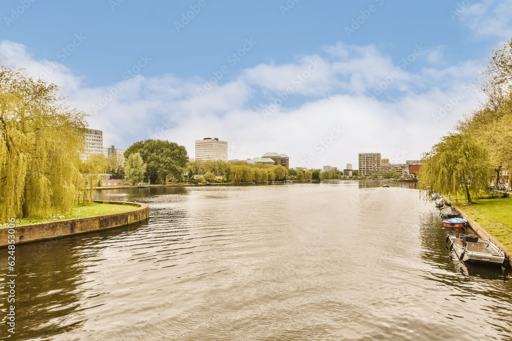 a river with boats and trees in the fore, taken from a boat on the water's edge as it passes by