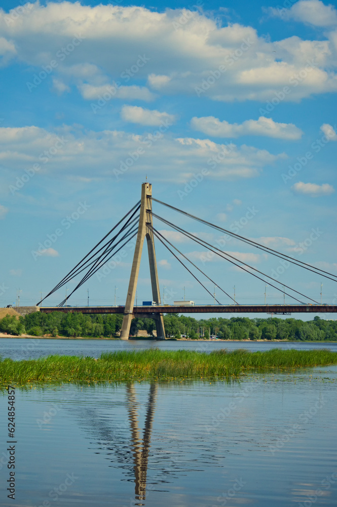 Scenic landscape view of bridge across Dnipro River in Kyiv, Ukraine. Pivnichnyi (Northern) bridge, cable-stayed bridge across the Dnipro. Infrastructure of a big city concept. Sunny summer day