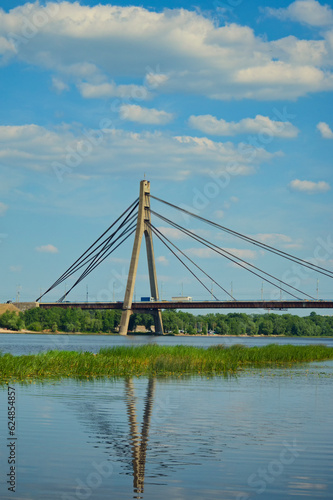 Scenic landscape view of bridge across Dnipro River in Kyiv, Ukraine. Pivnichnyi (Northern) bridge, cable-stayed bridge across the Dnipro. Infrastructure of a big city concept. Sunny summer day