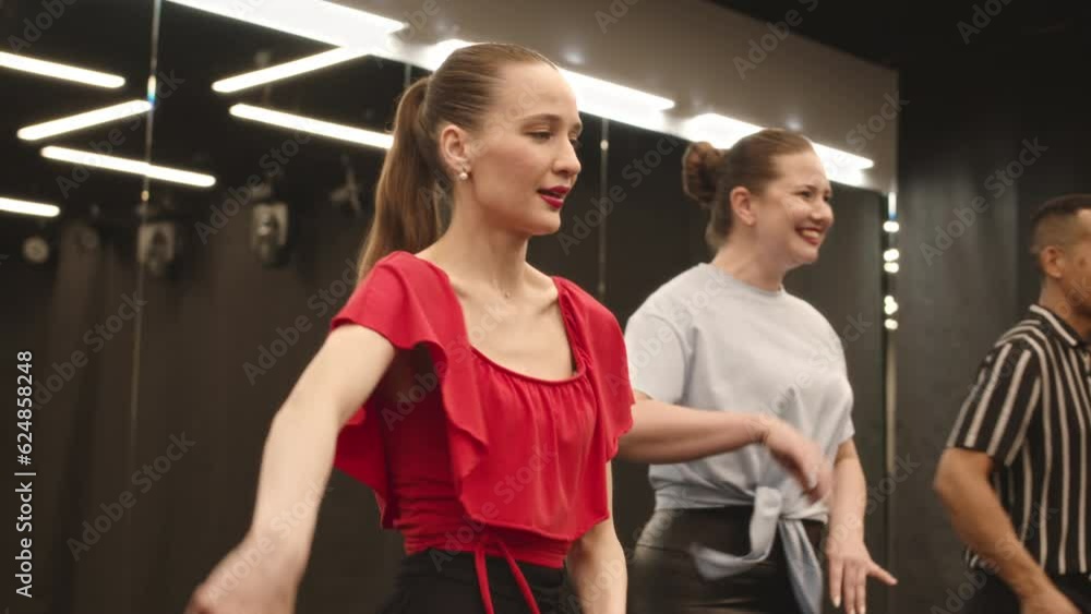 Medium slowmo of diverse cheerful young group of people dancing bachata together at dance studio Medium slowmo of diverse cheerful young group of people dancing bachata together at dance studio