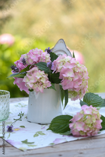 Vaso di ortensie rosa su un tavolo di legno collocato in un giardino