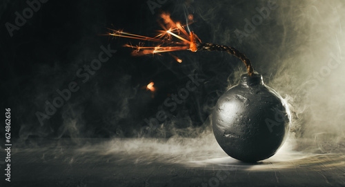 Round black bomb with lit fuse burning and sparking surrounded by smoke. Bomb about to detonate symbolizing destruction, threats, or dangerous violence. photo