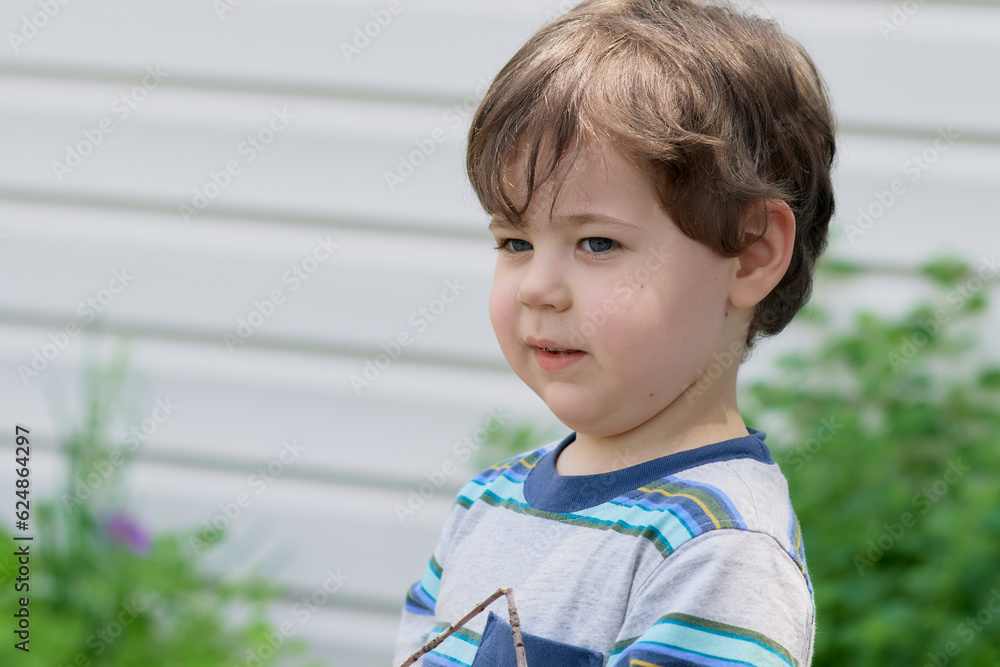 portrait of a cute baby boy playing with a stick in the backyard portrait of a cute baby boy playing with a stick in the backyard