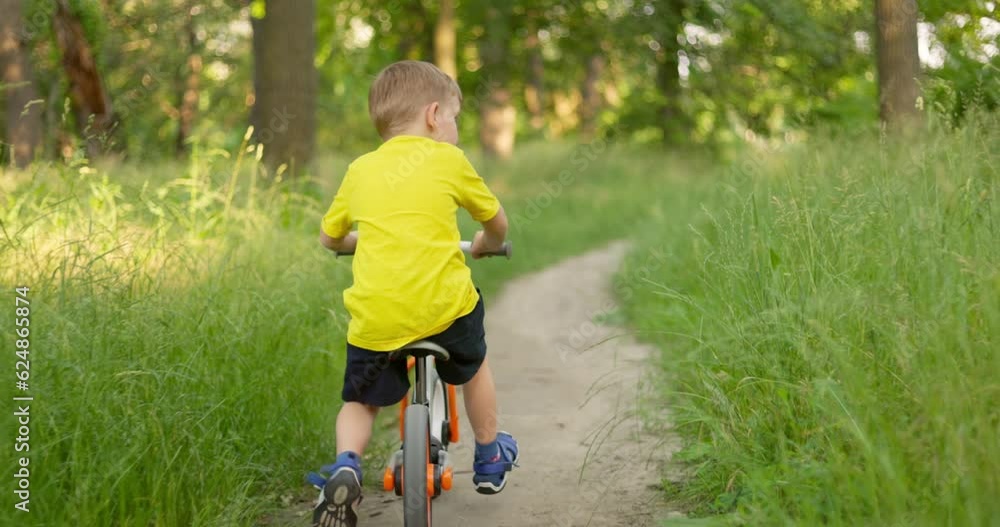 Child ride on bicycle through the forest on summertime vacations. Child ride on bicycle through the forest on summertime vacations.