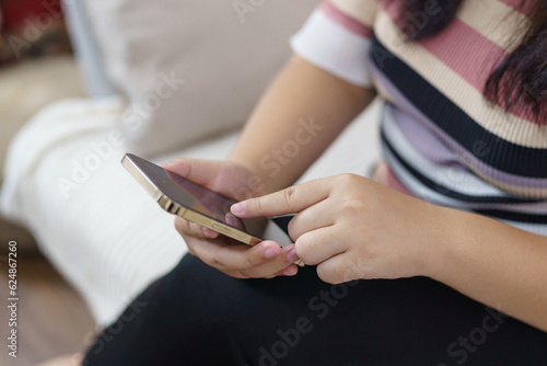 Woman hand using smartphone for checking social media or woman reading ebook on screen.