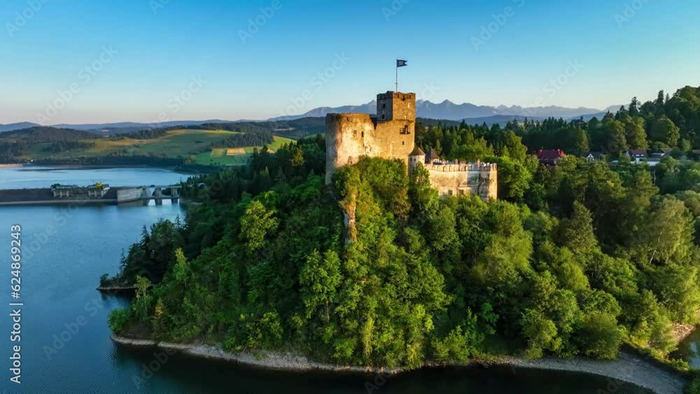 Poland. Medieval castle in Niedzica in sunset light. Artificial Czorsztyn lake on Dunajec river, damn and hydro power station. Tatra Mountains in the background. Aerial revealing video Poland. Medieval castle in Niedzica in sunset light. Artificial Czorsztyn lake on Dunajec river, damn and hydro power station. Tatra Mountains in the background. Aerial revealing video