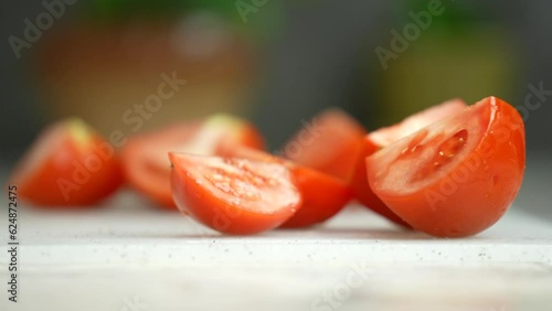 Sliced tomatoes, close-up, slow motion. Man's hand with a knife cuts tomatoes