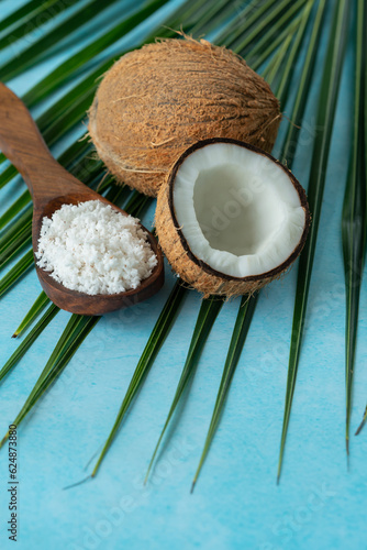 Half cut coconut with coconut flakes isolated on blue colour background