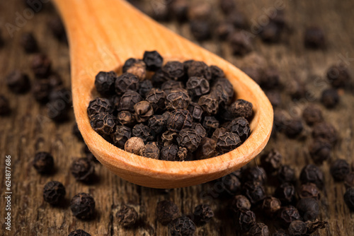 black pepper on wooden spoon