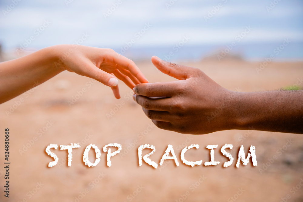 Φωτογραφία White hand of a woman and black of a man, concept of diversity with written sto