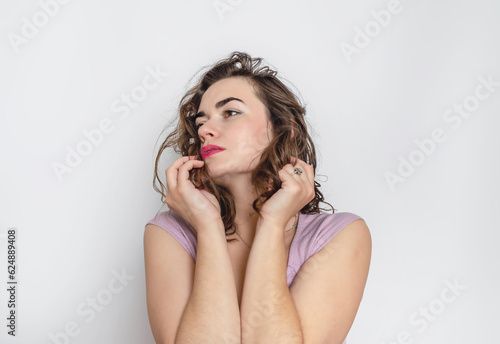 Pensive woman with hand near face. Dark wavy hair  black eyebrows  big brown eyes.