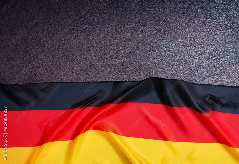 Obraz premium germany flag on dark table background with copy space