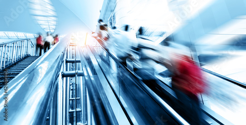 Bild auf Leinwand People rush on escalator motion blurred