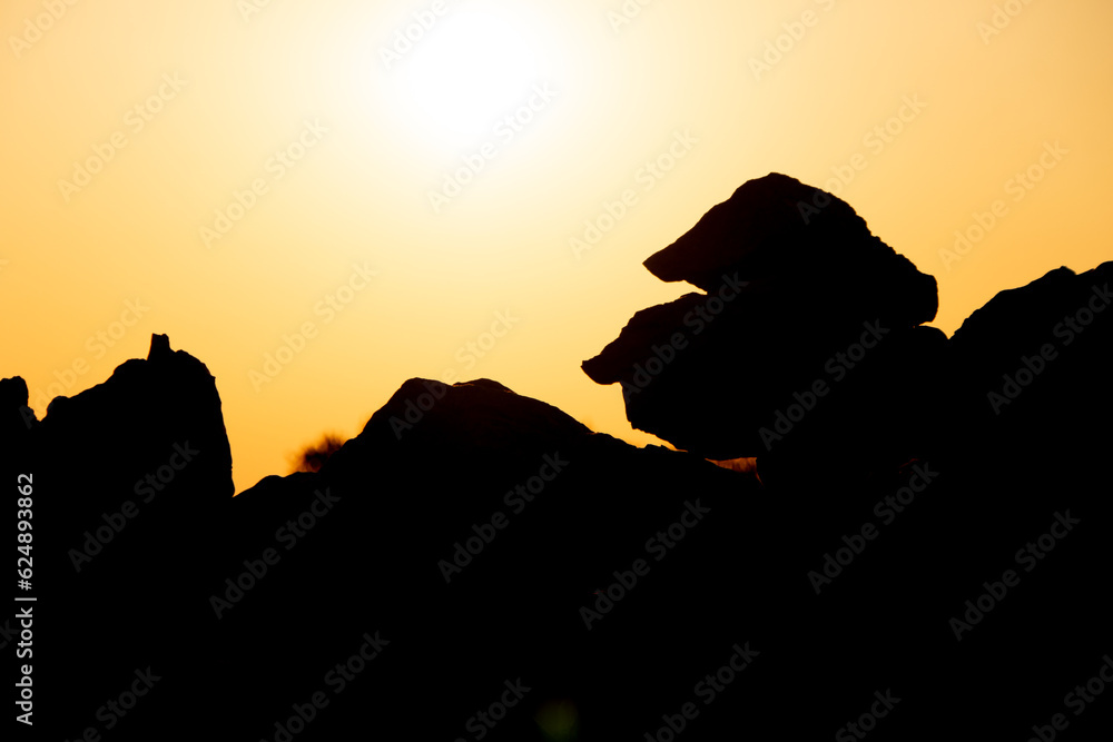 Steine im Vordergrund mit Sonnenuntergang im Hintergrund