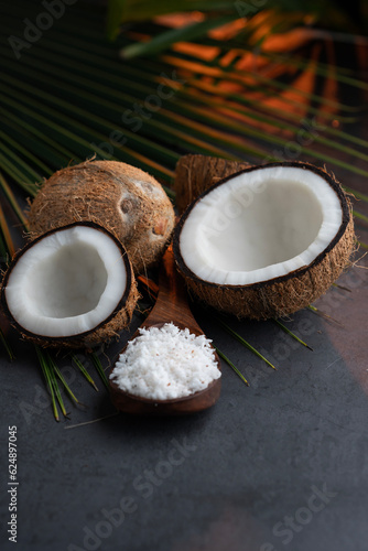 coconut week concept image, fresh half cut coconut with coconut flakes on a wooden spoon