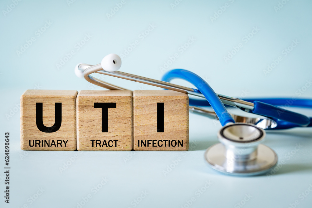 Medical stethoscope and wooden blocks with the medical abbreviation UTI for Urinary Tract Infection, Medical concept, beautiful blue background