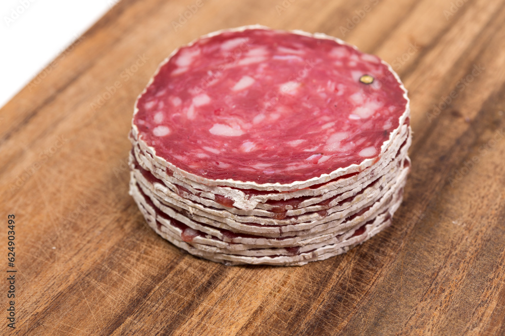 Slices of salami on wooden board Slices of salami on wooden board