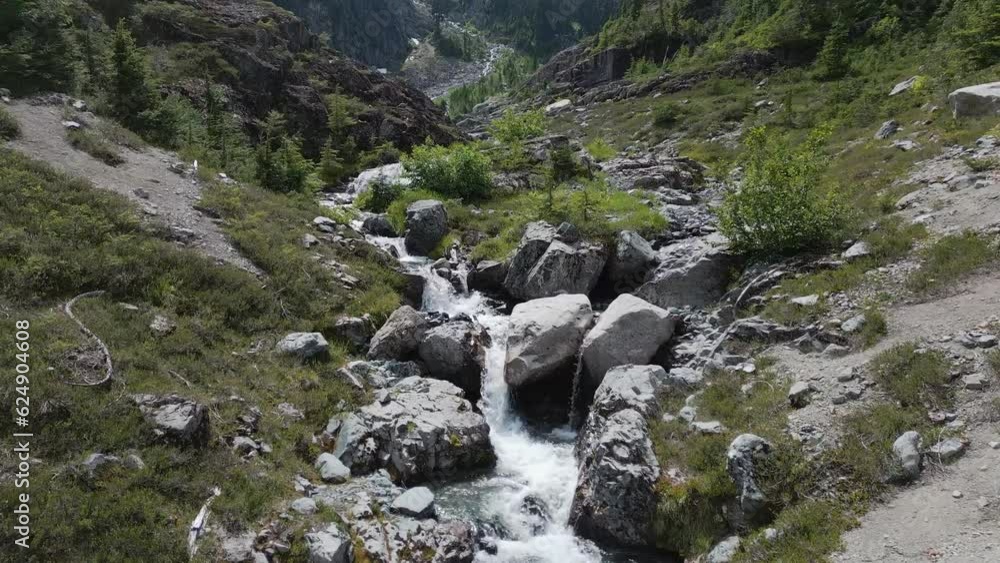 River running down the mountain by rocks and trees. River running down the mountain by rocks and trees.