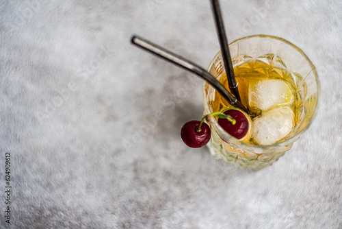 Glass of lemonade garnished with cherry