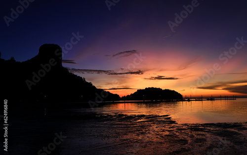 Long exposure to Beautiful rock on the sea against the twilight dark sky. © naraichal