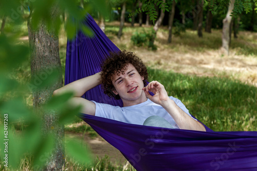 Young guy resting in a hammock in nature © Oleg