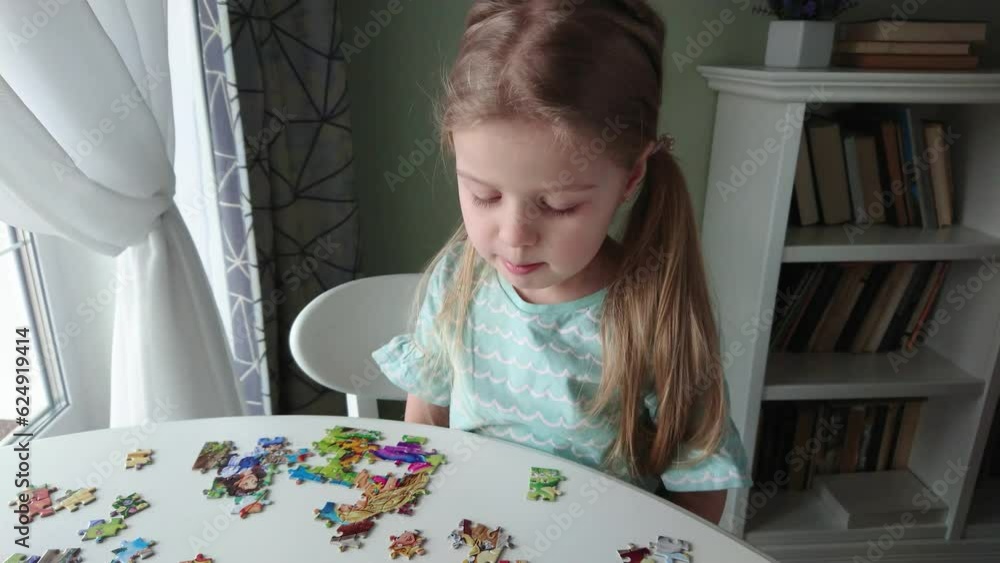 Little child picks up picture from pieces of puzzles Little child picks up picture from pieces of puzzles