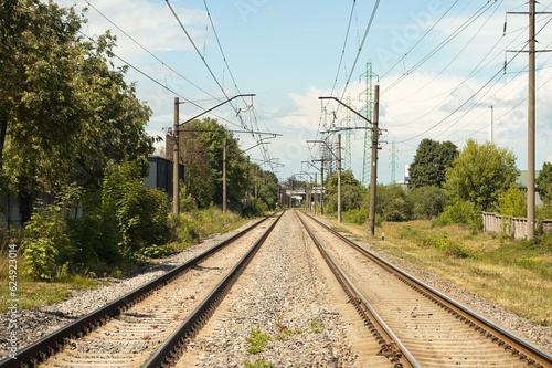 railway, in the photo rails against the background of a blue sky and clouds