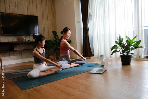 Healthy family mother and little girl practice yoga at home, new normal lifestyle