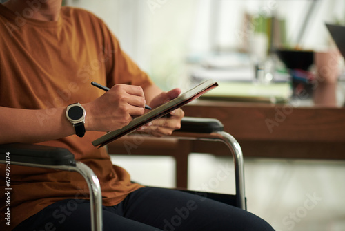 Cropped image of creative college student with disability drawing sketch on digital tablet