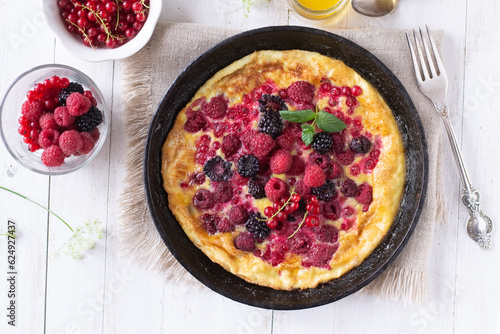 Omelet with berries on wooden table