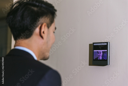 Man using face scanner to unlock door in office building. Access control facial recognition system. Biometric admittance control device for security system. Biometric admittance control device