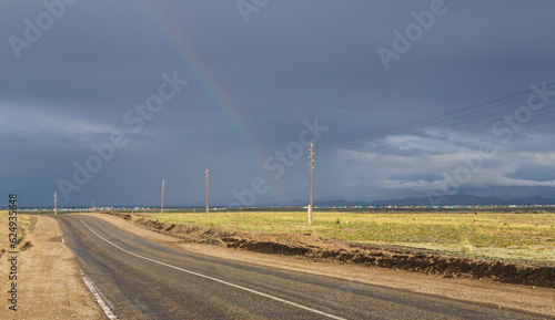 Chuysky Trakt, Chuya Highway trunk road in Novosibirsk Oblast, Altai Krai and Altai Republic of Russia. Soutern part with a rainbow and dark sky photo