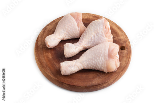Raw chicken legs on a wooden cutting board isolated on white. Side view.