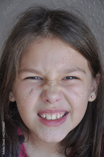 menina criança fazendo careta expressão facial  photo