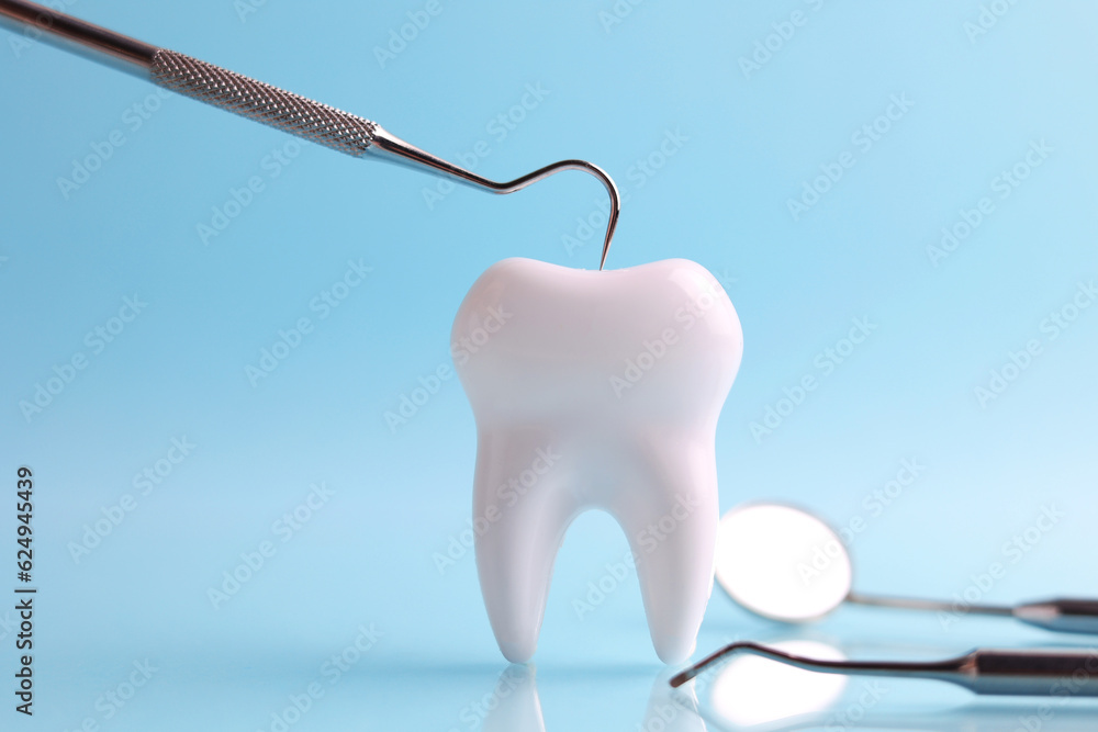 Dentistry concept. Model of a tooth and dental instruments on a colored background with space for text. Dentistry concept. Model of a tooth and dental instruments on a colored background with space for text.