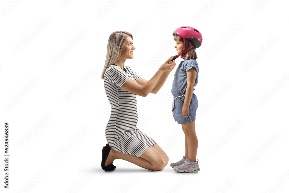 Mother putting on a helmet at a daughters head Mother putting on a helmet at a daughters head