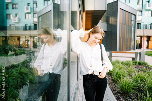 beautiful young girl in white shirt is walking on aity street, woman is resting outdoors photo