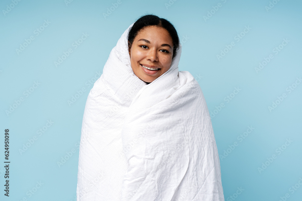 Happy african american woman relaxing at home wrapped in soft blanket Happy african american woman relaxing at home wrapped in soft blanket