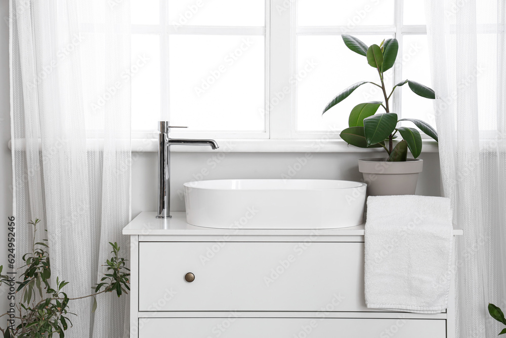 Φωτογραφία Sink bowl, faucet and houseplant on chest of drawers near window